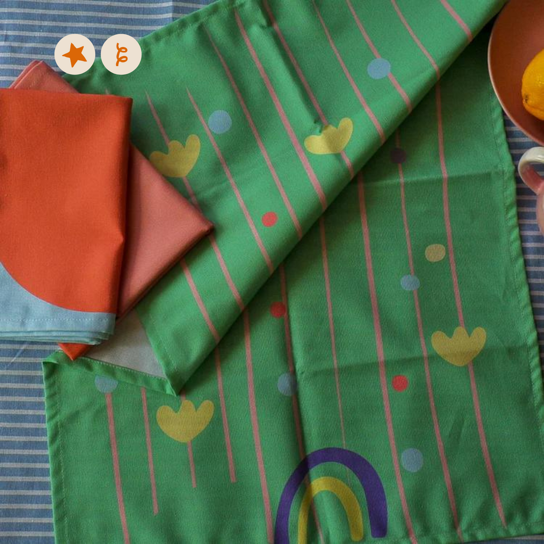 Green tea towel with pink lines, red blue and yellow dots, and blue and yellow rainbows