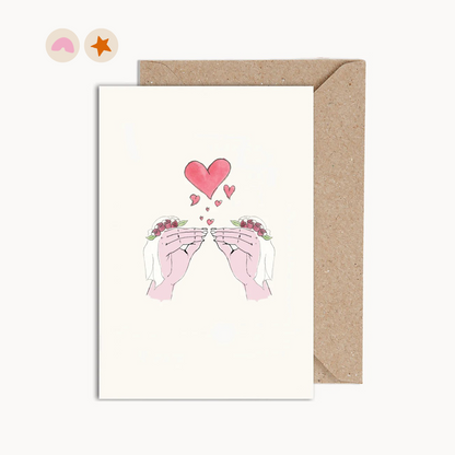 Card with an illustration of two hand kissing with hearts, both hands are wearing veils.
